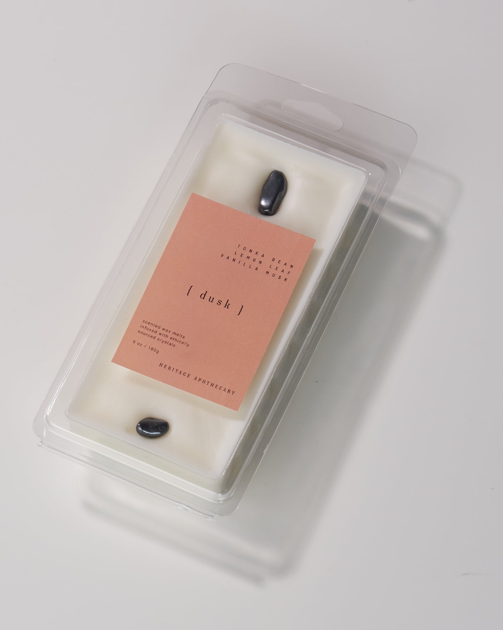 Handcrafted coconut and soy wax melts in Dusk scent. Lemon, jasmine, cyclamen, rose, vanilla, and musk notes. Hematite crystals for a touch of luxury. Elevate your home fragrance.